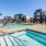 Large sparkling blue pool with a large pool deck and lounge chairs