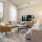 Spacious and well lit living room with wood flooring, large windows and open access to the kitchen