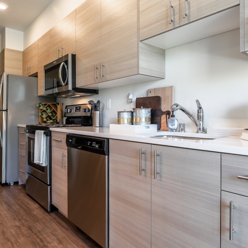 Kitchen Spacious and well lit kitchen with wood flooring and stainless steel appliances